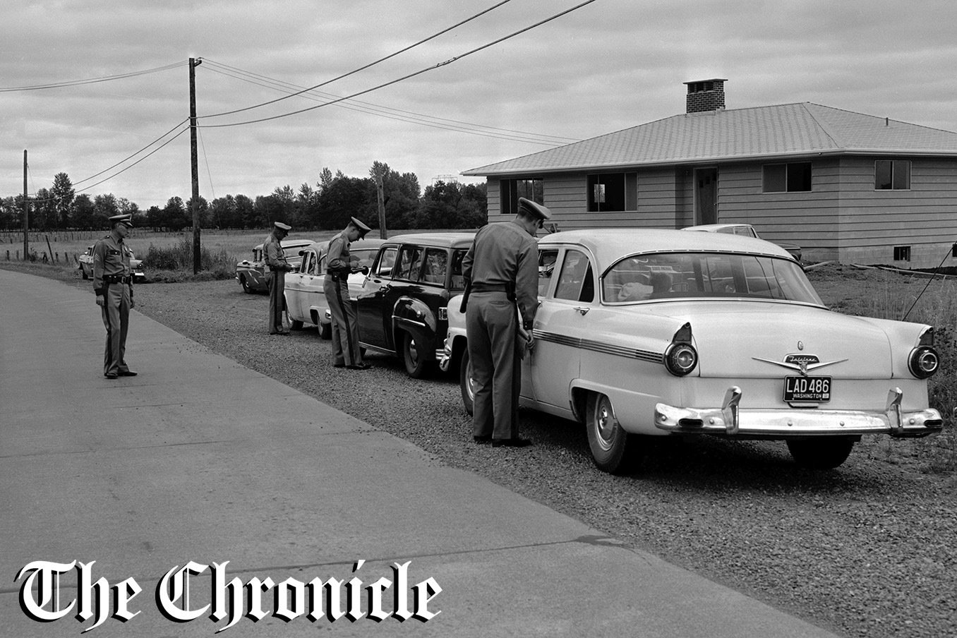 From the news clipping: “DRIVER SHAKEDOWN — Lewis County Drivers are getting what they’ve been looking for - a crackdown on drivers with expired operators’ licenses. Above, at left, State Patrol Sergt. Harold Cusie of Chehalis watches three patrolmen check drivers at a spot check location Saturday. That was at Mary’s Corner at intersection with former “99”. Of 178 drivers, there were three arrests and three warnings. Friday officers checked 201 cars, found nine drivers with expired licenses. - Chronicle Staff Photo.”
